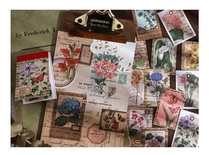 Vue détaillée de 50 autocollants floraux vintage pour scrapbooking sur fond bois rustique