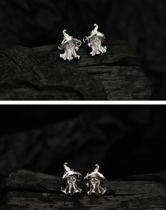 Macro shot of S925 silver ghost and witch hat earrings with intricate holiday details