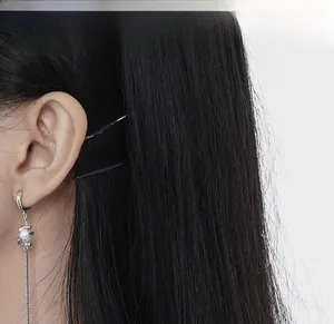 Detail of silver drop earrings with white pearls and long chain tassels on a model