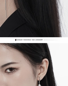 Detail of silver tassel chain earrings and sleek necklace on a female model
