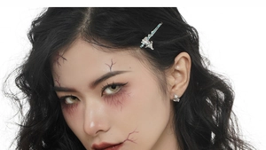 Close-up of silver ghost earrings with blue enamel and Halloween zombie makeup effects
