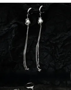 Detailed view of silver tassel earrings with delicate chains and elegant white pearls