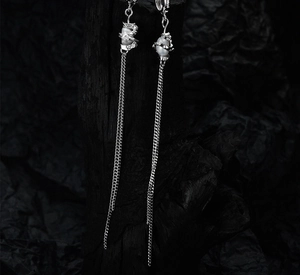 Close-up of elegant S925 silver fringe earrings with lustrous white pearls on dark background