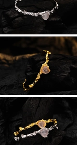 Macro detail of silver and gold branch textured bracelets with pink heart agate gems