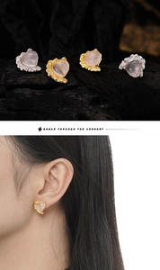 Detail of heart-shaped rose quartz earrings with textured lava metal frames on model