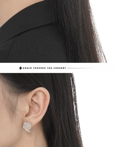 Close-up of pink heart stud earring in S925 sterling silver worn on a woman's ear