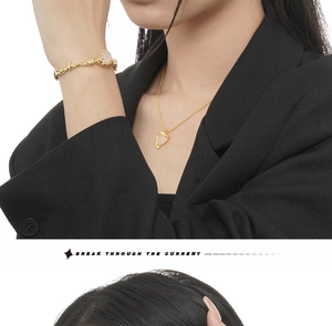 Close-up of lava texture gold necklace and bracelet set with pink agate on model