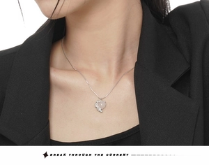 S925 silver heart pendant necklace with pink crystal on model wearing black suit