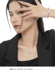 Close-up of a pink heart gemstone jewelry set on a model in a black suit