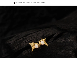 Macro shot of S925 silver irregular star studs with opal inlay on dark wood background
