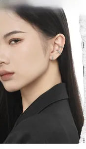 Detail of silver S925 ear cuffs set with mint green stones on model's ear