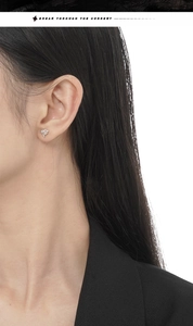 Detail of star-shaped S925 silver stud earring with opal stone on a female model