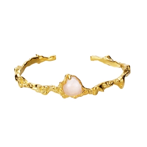 Adjustable gold lava texture bangle featuring an organic pink quartz gemstone inlay