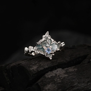 Bague en argent S925 texturé avec pierre bleue claire sur fond de charbon de bois