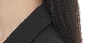 Close-up of premium black high-density twill fabric on a formal suit jacket collar