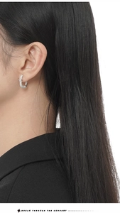 Detail of silver S925 sterling silver hoop earrings with pavé zircons and star charms