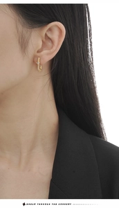 Detailed view of luxury gold earrings with square-cut cubic zirconia on a model