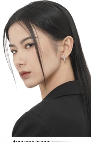 Close-up detail of silver S925 hoop earrings with sparkling pavé zircons on model