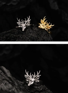Makroaufnahme von Rentier-Ringen in Silber und Gold mit 3D-Geweih auf dunklem Grund