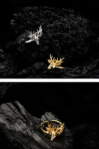 Macro detail of elk head rings in gold and silver finish on textured black charcoal base