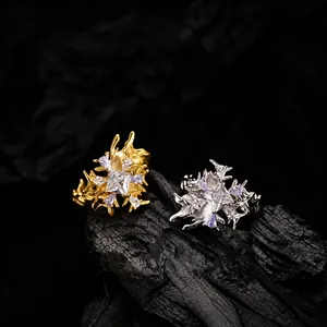 Macro de anillos dorados y plateados estilo metal líquido con circonitas en carbón