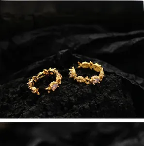Macro shot of 18K gold open rings with irregular texture and three opal stones
