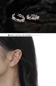 Detail of lava texture silver and gold ear cuffs with purple stones on charcoal wood