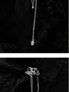 Macro detail of silver S925 chain ear cuff with white pearls on dark carbon background