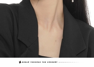 Detailed close-up of notch lapel and fine twill fabric on black blazer jacket