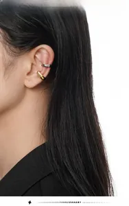 Gros plan de manchettes d'oreilles minimalistes dorées et argentées sur le mannequin