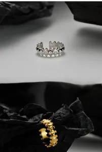 Détail d'une bague géométrique à pointes en or et argent avec poinçon S925