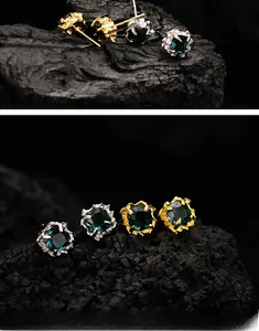 Macro detail of S925 silver square gemstone earrings with rustic gold and silver textures