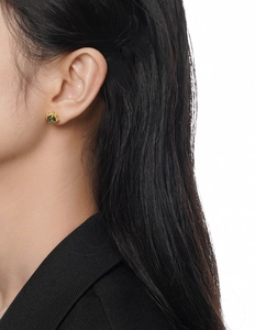 Detailed close-up of a vintage S925 silver stud earring with emerald green gemstone