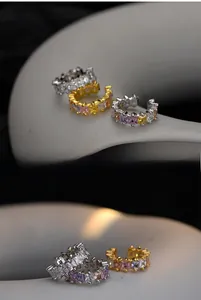 Détail macro de boucles d'oreilles en argent S925 avec zircons colorés incrustés