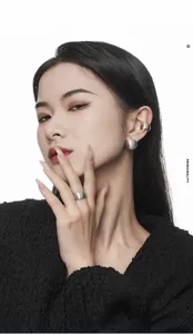 Detail of matte brushed silver ball studs and chunky rings on model for a minimalist look