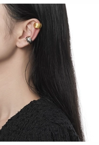 Detail of matte gold and polished silver S925 sterling silver ear cuffs on an ear