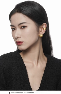 Detailed close-up of matte gold textured ear cuff and ball stud earring on ear