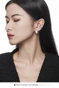 Macro shot of S925 sterling silver brushed sphere stud earring and ear cuff on model