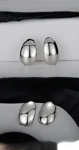 Close-up of S925 silver earrings with irregular liquid metal texture and glossy finish