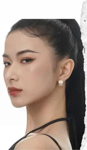 Close-up of dual-tone gold and silver hoop earrings with inset zircon on female model