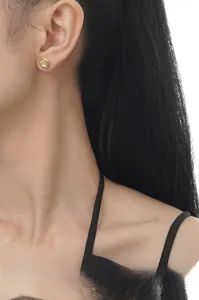 Close-up of a 925 sterling silver ear stud with white agate on a model ear