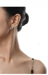 Dettaglio dell'orecchino in argento S925 stile metallo liquido sulla modella con finitura lucida