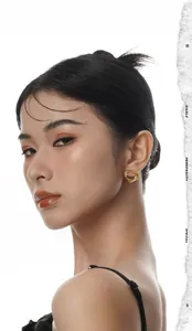 Gros plan de boucles d'oreilles géométriques torsadées en or portées par un mannequin