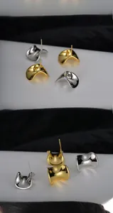 Dettaglio di orecchini a perno curvi irregolari lucidi in finiture argento e oro