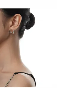 Détail de boucles d'oreilles S925 géométriques argentées au fini poli miroir sur le modèle