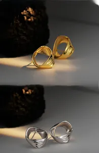 Détails macro de boucles d'oreilles C géométriques creuses avec triple rainures en or et argent