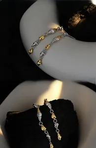 Detailed view of dual-tone baroque pearl tassel earrings with gold and silver links