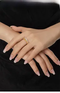 Close-up of stacked irregular gold textured ring and silver zircon band on a model hand