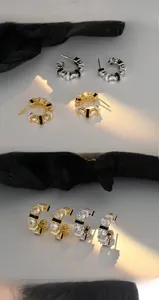 Macro detail of C-shaped enamel earrings featuring sparkling cubic zirconia and high polish