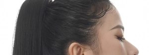 Detail view of smooth black high ponytail hair extension on model with natural texture